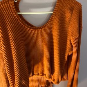 A rusty orange sweater form Hollister in size XS.